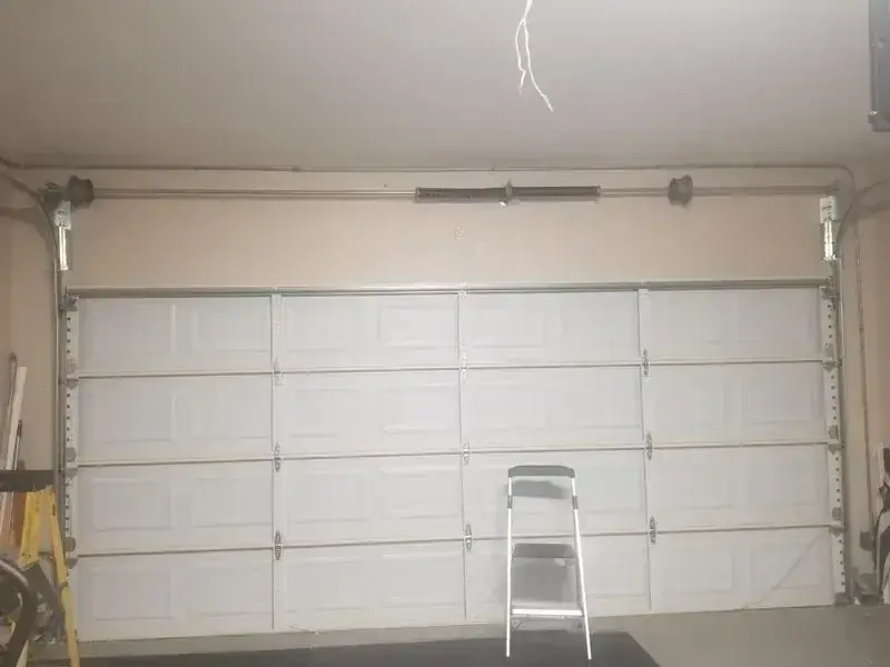 There is a ladder in the garage next to the garage door.