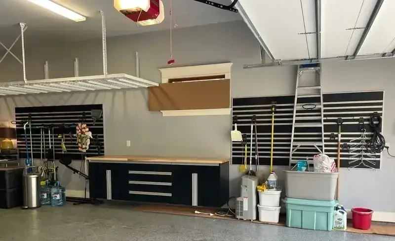 A garage with a table , boxes , and a ladder.