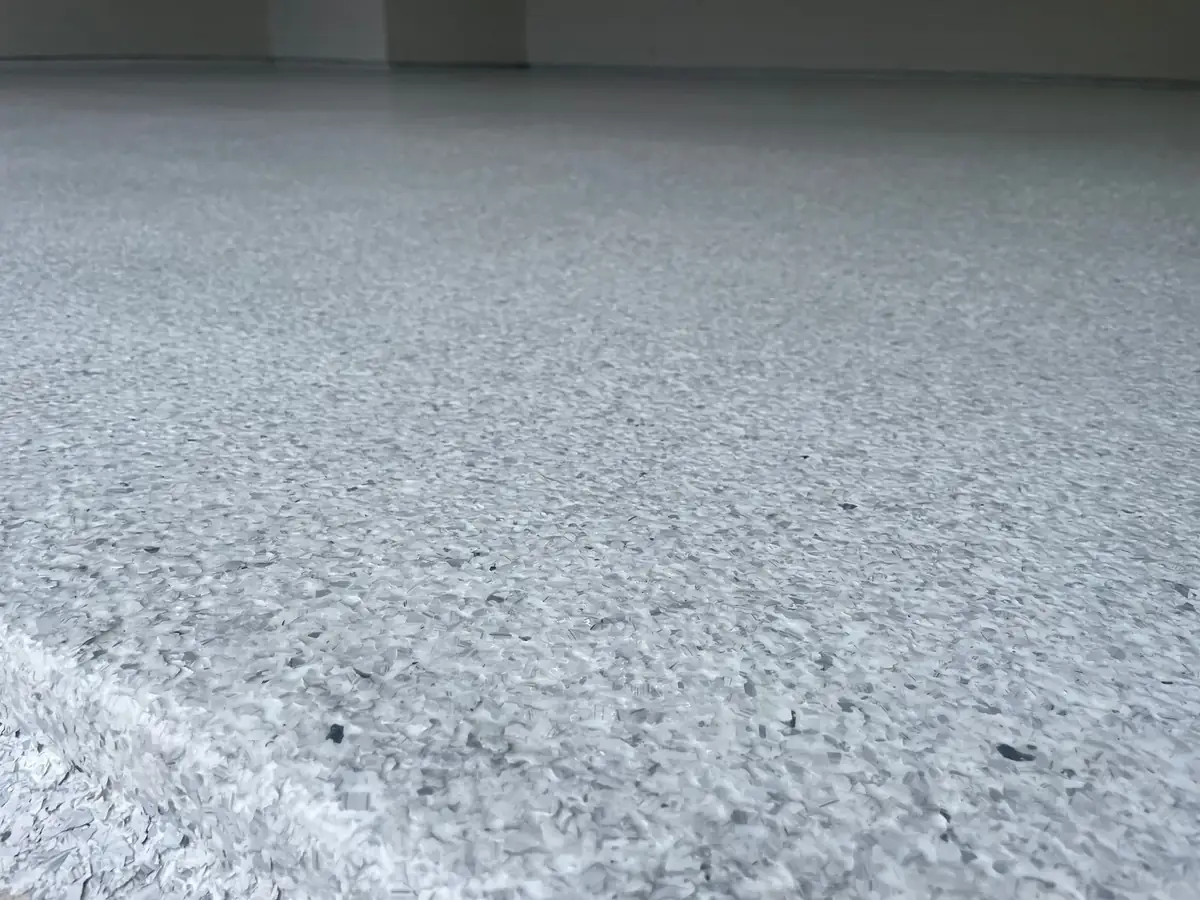 A close up of a gray carpeted floor in a room.