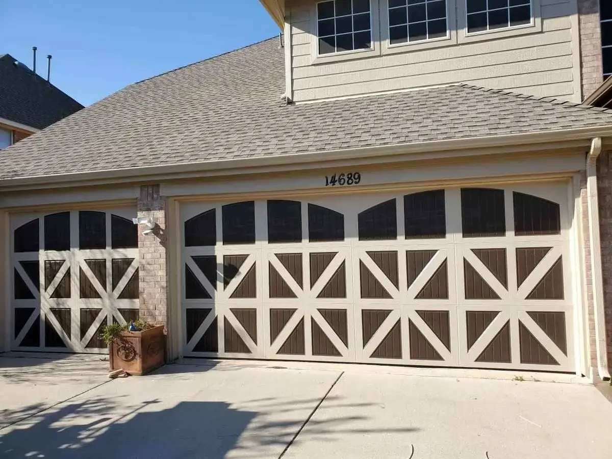A large house with two garage doors and a roof