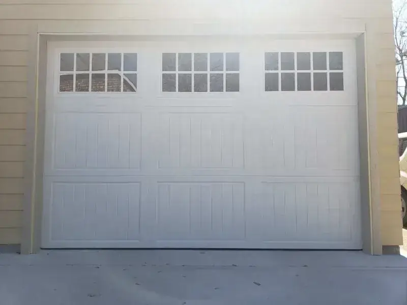 A white garage door with a lot of windows on it