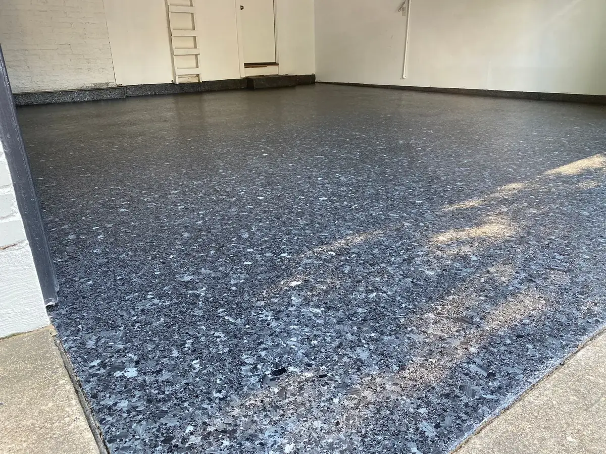 A garage floor with a ladder in the background.