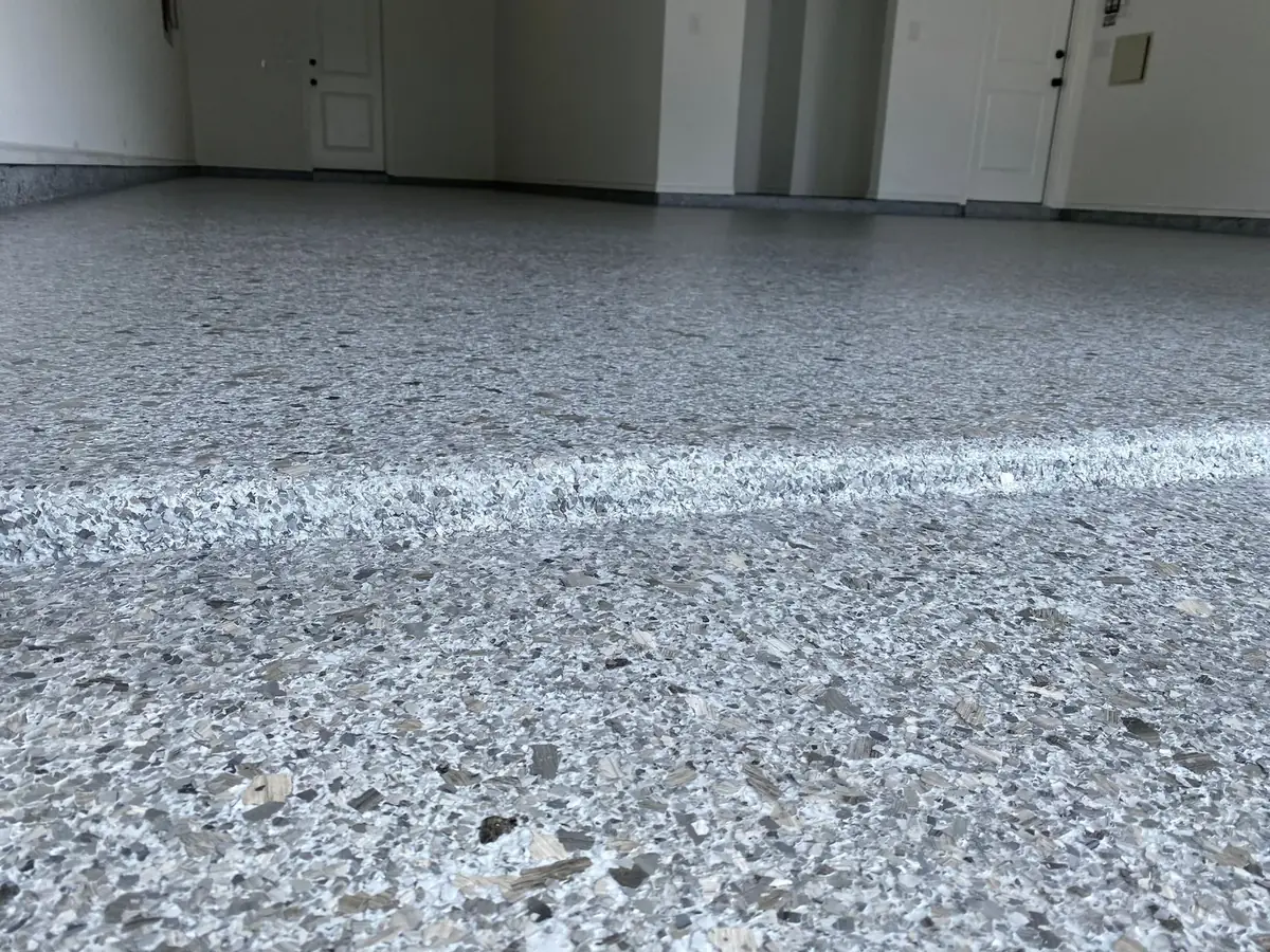A close up of a garage floor with a white line on it.